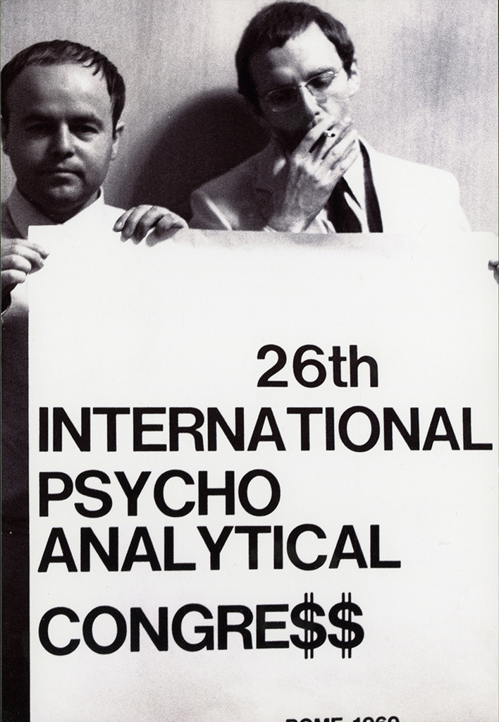 Elvio Fachinelli e Berthold Rothschild durante il "controcongresso", con il cartello "26th International Psycho Analytical Congre$” (© Lisetta Carmi 1969, Collezione privata)