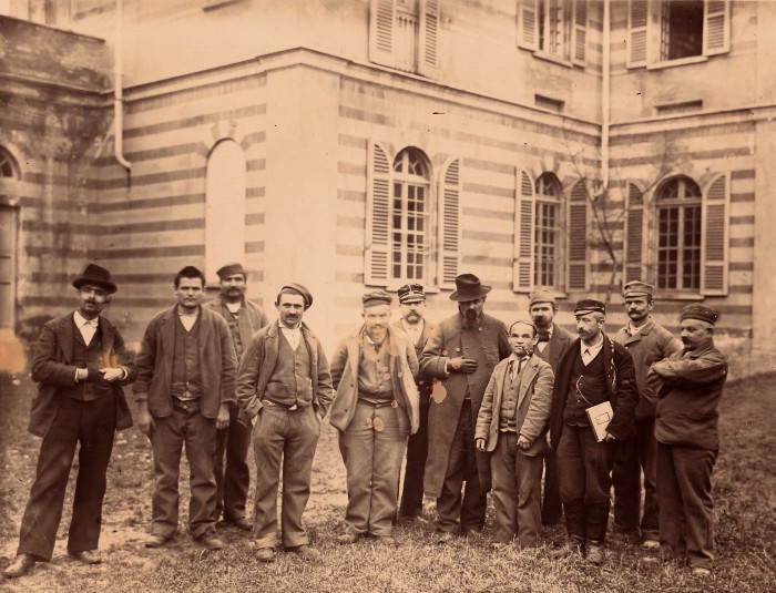 Foto di gruppo dei degenti uomini, alcuni dei quali vestiti per una rappresentazione teatrale, s.d.